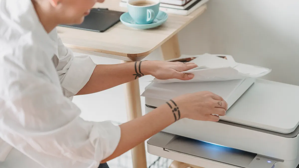 Person loading paper into a printer