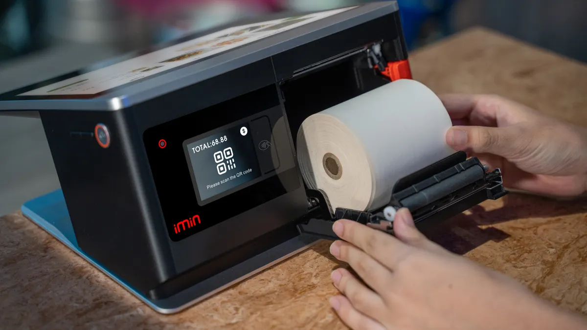 Printer setup, installation, and first-time use — The Complete Guide Hands loading paper into a desktop label printer